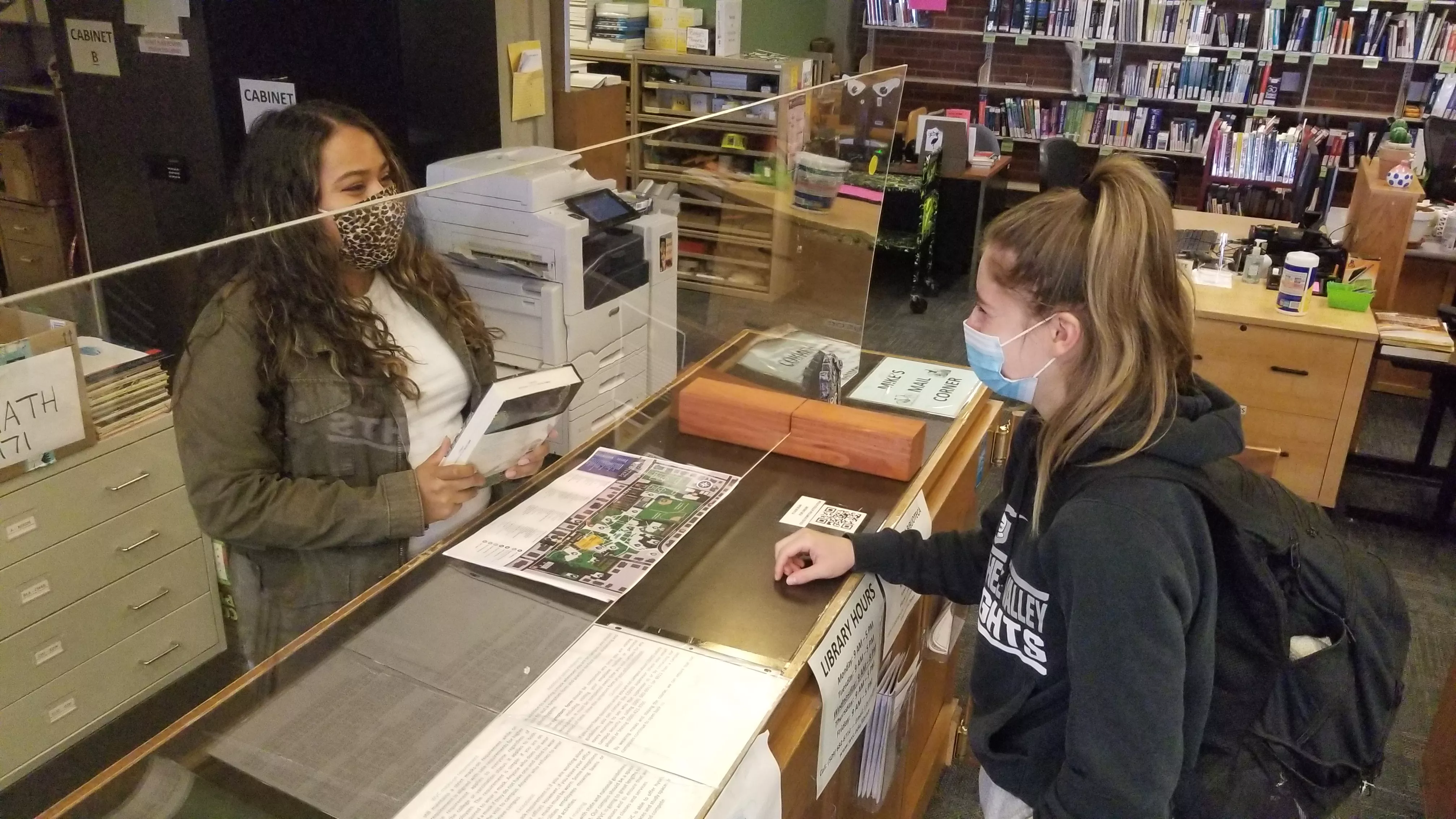 2 people at library circulation counter